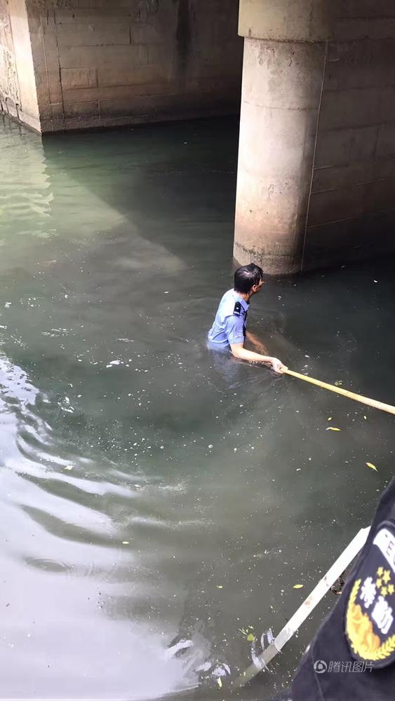 Policeman tries to salvage admission card in dirty river