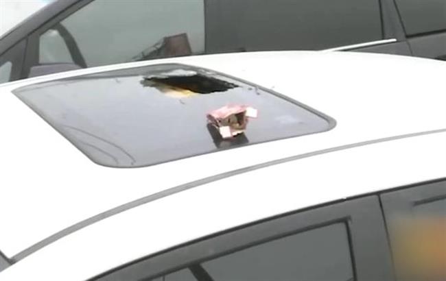 Falling cigarette box with lock inside smashes car sunroof