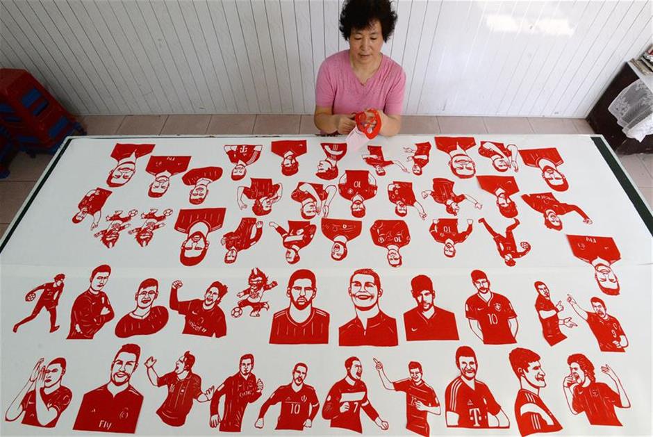 Craftswoman makes paper-cutting works to greet World Cup