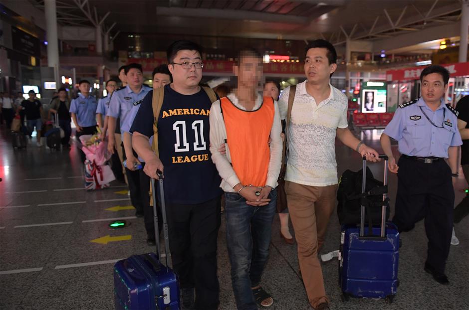 Police bring fraud suspects to Shanghai