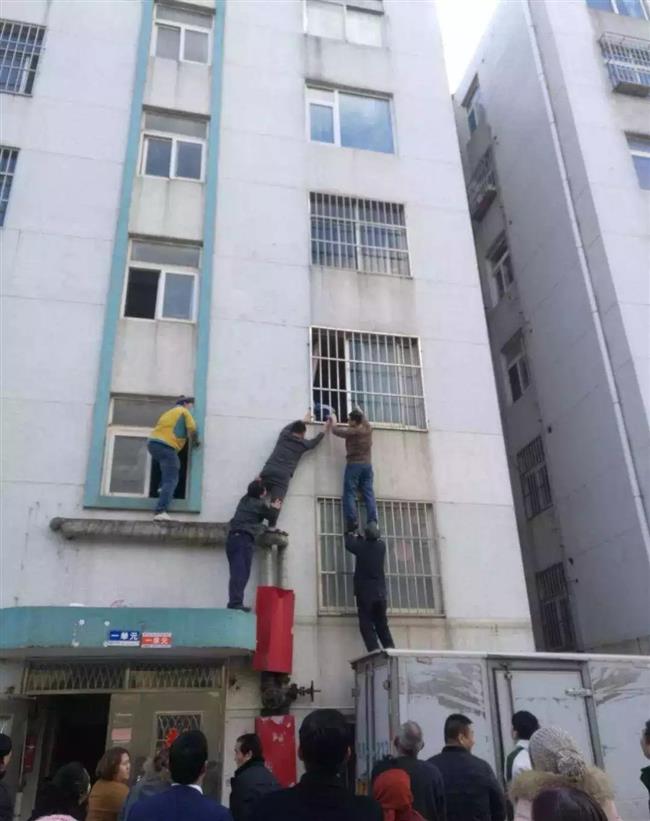 Neighbors join hands to save toddler stuck in window