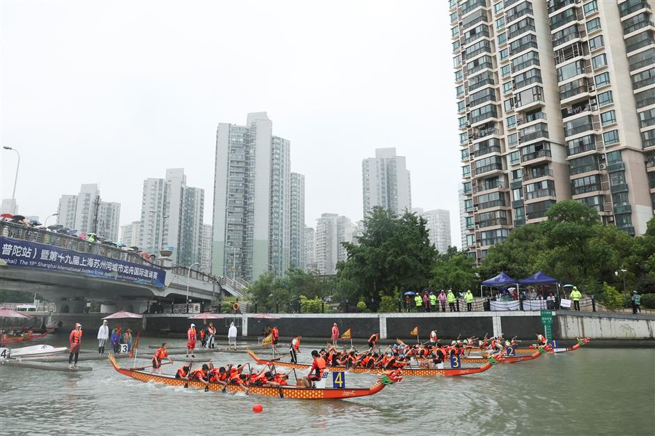 Dragon boat rowers defy heavy rain to make a splash on Suzhou Creek